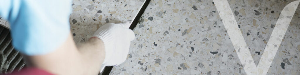 A bricklayer laying a terrazzo tile